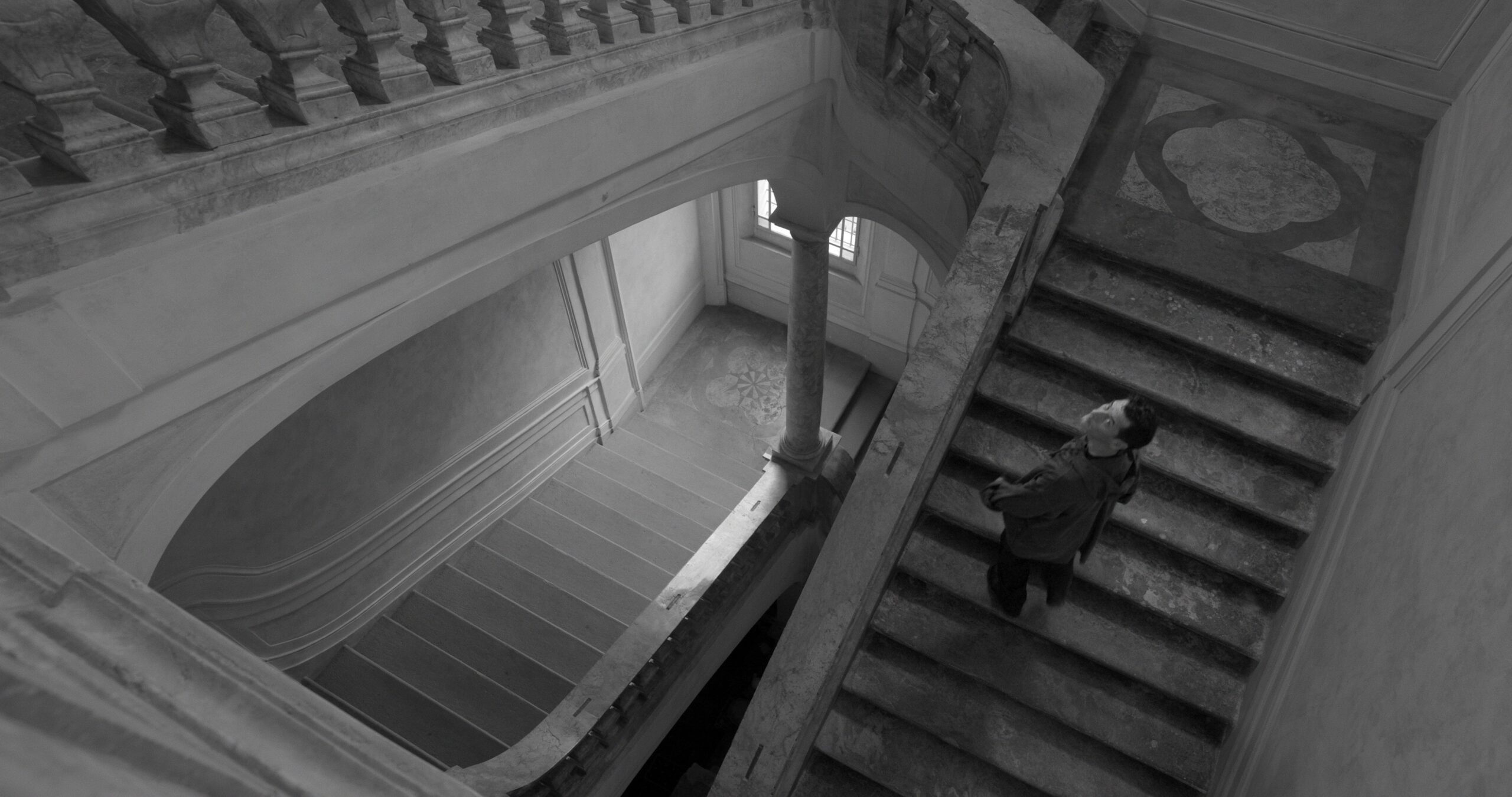 uomo in mezzo ad una scalinata che guarda in alto